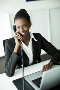 Young african woman in the office with mobile phone